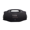 Parlante portátil JBL negro con asa superior y logo visible en vista frontal en la playa