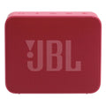 Parlante portátil JBL rojo sobre césped junto a carpa azul en vista superior