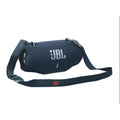 Parlante portátil JBL azul oscuro con malla texturizada y botones frontales en primer plano
